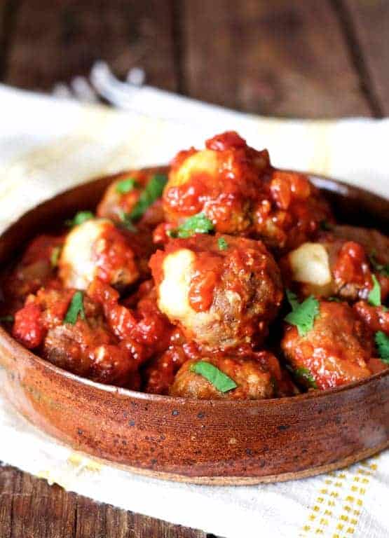 Pepperjack-Stuffed Meatballs with Chipotle Sauce in earthenware serving bowl.
