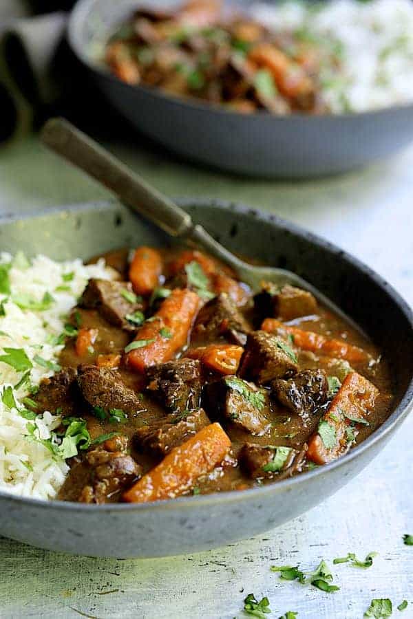Close-up photo of a serving of Pressure Cooker Indian Curry Beef Stew in gray bowl.