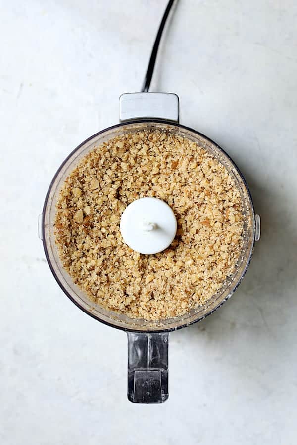 Overhead shot of finely chopped walnuts in mini food processor