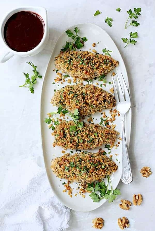 Four pieces of Walnut-Crusted Chicken on oval white platter.