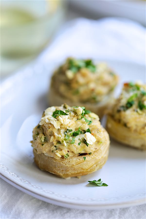 Close-up photo of three Deviled Crab Stuffed Artichoke Bottoms on white plate.