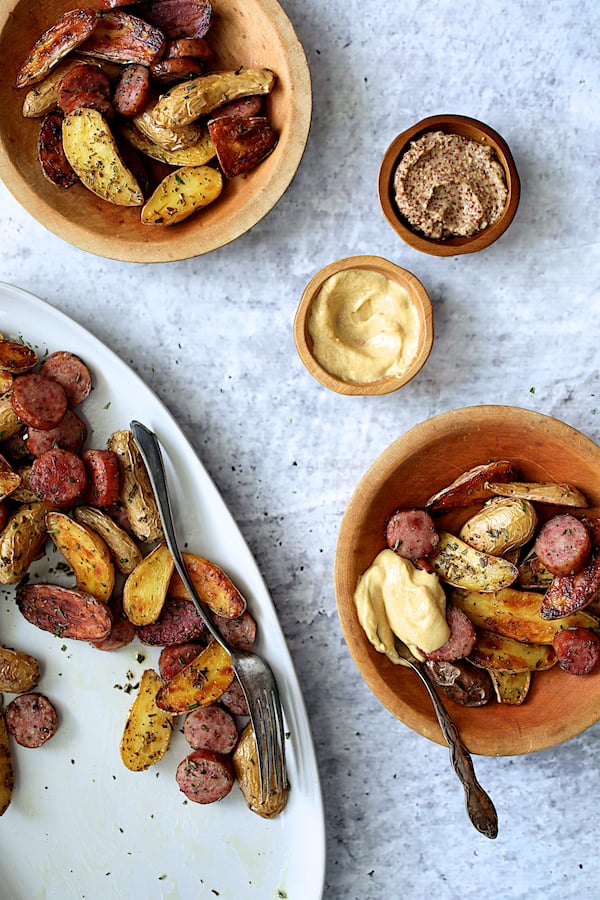 Photo of Duck Fat and Rosemary Roasted Fingerling Potatoes with Sausage with some served into wooden bowls.