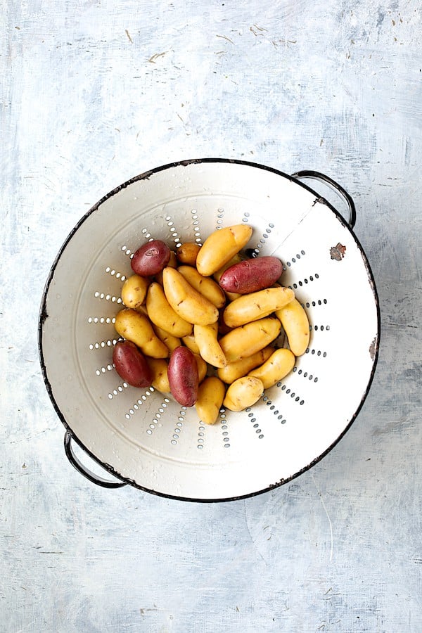 Photo of fingerling potatoes in white vintage colander.
