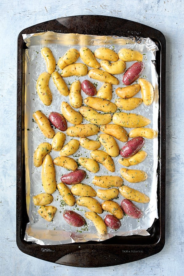 Photo of halved potatoes on sheet pan ready to be roasted.