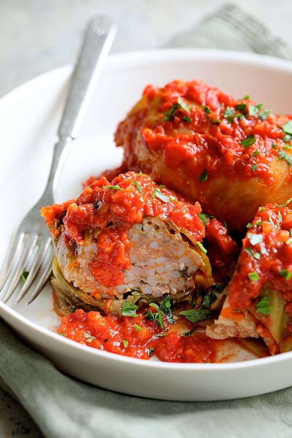 Spicy Italian Stuffed Cabbage - Close-up shot of cabbage rolls with one cut in half to expose filling