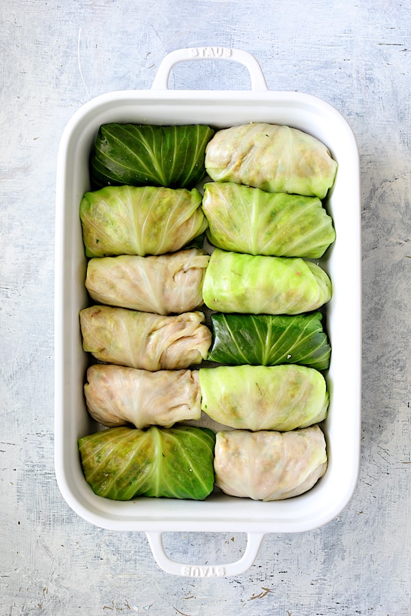 Spicy Italian Stuffed Cabbage - Overhead shot of all the cabbage rolled and placed in white baking dish