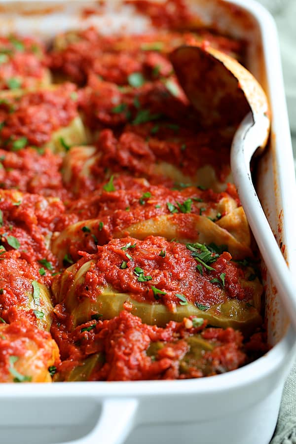 Spicy Italian Stuffed Cabbage - Straight-on shot of baked dish with white serving spoon