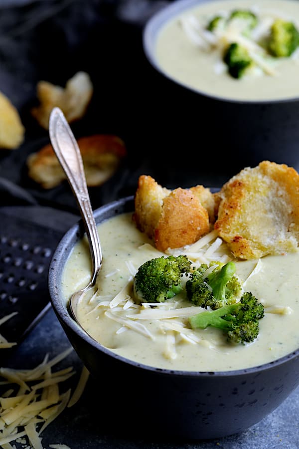 Broccoli Gruyere Soup with Torn Garlic Croutons - Straight-on close-up shot of soup garnished with broccoli, cheese and croutons
