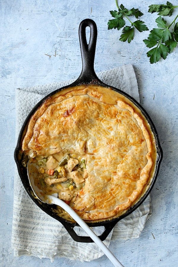 Photo of Cheesy Skillet Chicken Pot Pie with some served to expose the filling.