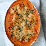 Shrimp Scallop and Artichoke Lasagna in oval white baking dish.