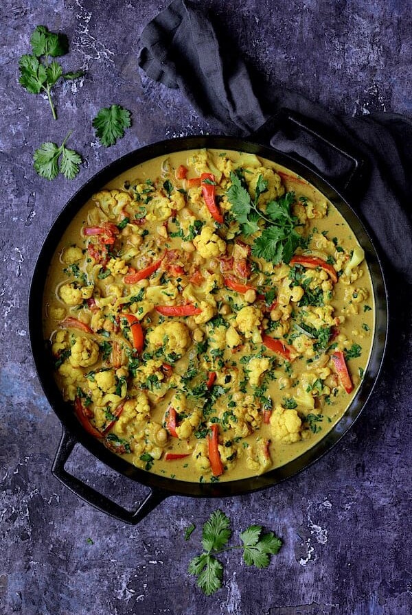 Vegan Indian Cauliflower and Chickpea Curry in a black cast iron pan.