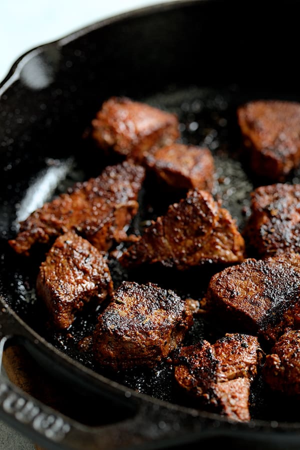 Buttery Blackened Steak Bites with Gorgonzola - Steak bites being browned in cast iron skillet