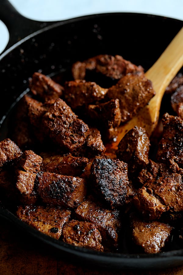 Buttery Blackened Steak Bites with Gorgonzola - Steak bites being tossed with butter in cast iron skillet