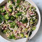 Lemony Broccoli, Barley and Bean Salad in white serving bowl with serving spoon.