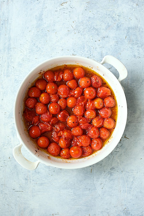 Photo of roasted tomatoes in white baking dish.