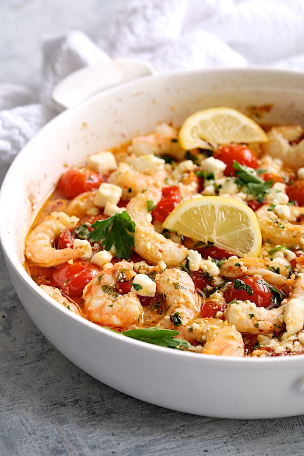 Photo of Spicy Baked Shrimp with Tomatoes and Feta Cheese garnished with parsley and lemon.