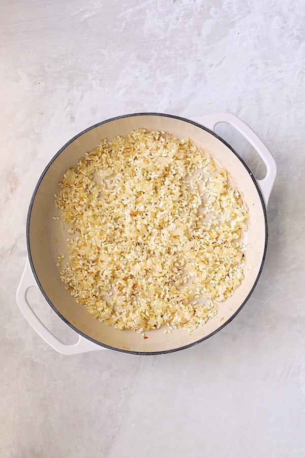 Photo of uncooked risotto in white cast iron pan.