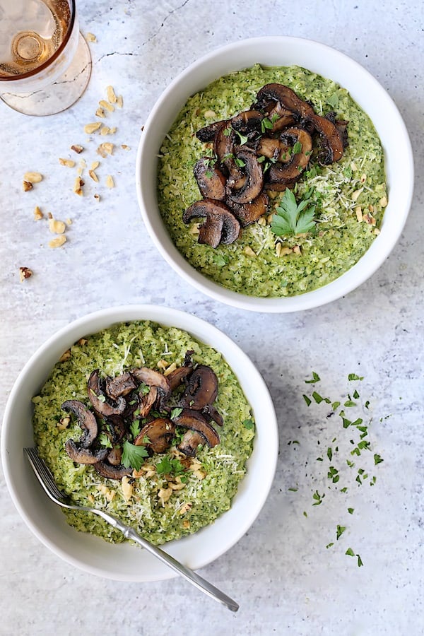 Photo of two servings of Oven Risotto with Kale Pesto and Roasted Mushrooms garnished with fresh parsley.