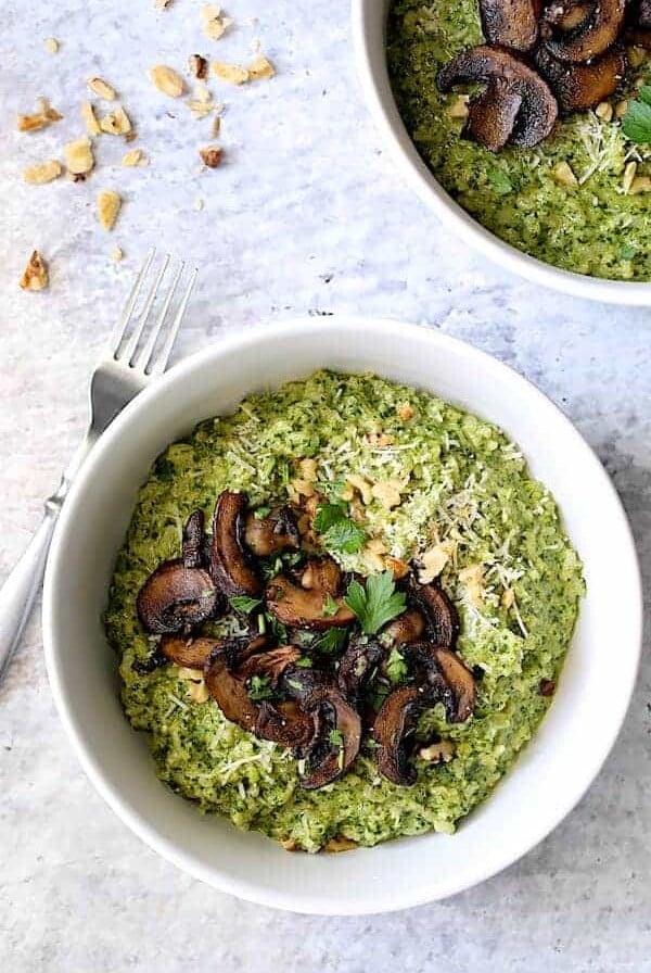 One serving of Oven Risotto with Kale Pesto and Roasted Mushrooms in white dinner bowl.