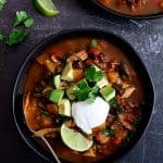 One serving of Slow Cooker Southwestern Turkey, Butternut Squash and Black Bean Stew in black bowls.