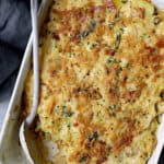 Country-Style Potato and Cabbage Casserole with Cheddar and Bacon in white rectangular baking dish with white serving spoon.
