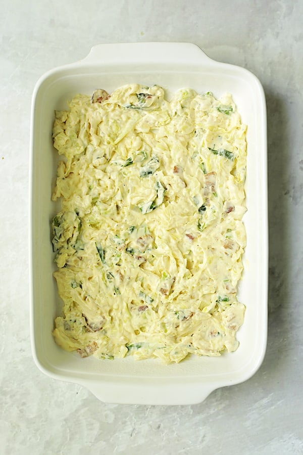 Photo of first layer of cabbage in white rectangular baking dish.