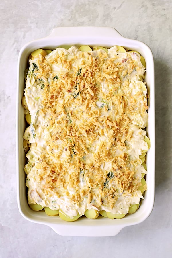 Photo of final layer placed in white baking dish with topping of French fried onions.