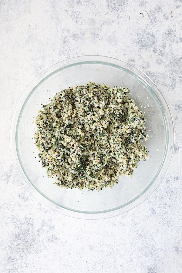 Photo of quinoa cake ingredients combined in glass bowl.