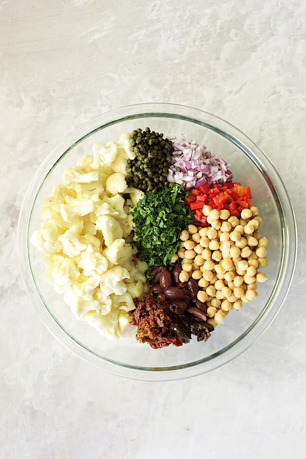 Photo of ingredients for Sicilian Cauliflower Salad in glass bowl.