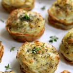 Garlic Herb Muffin Pan Potato Galettes on white background garnished with fresh thyme.