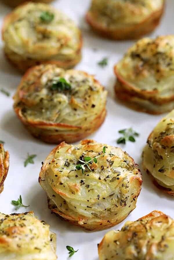 Garlic Herb Muffin Pan Potato Galettes on white background garnished with fresh thyme.