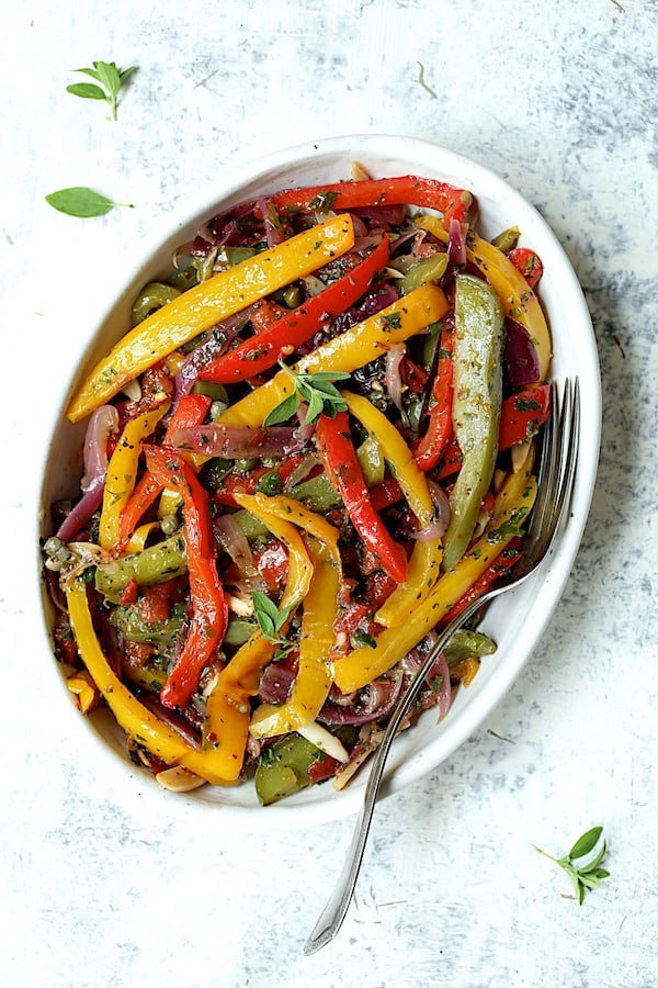 Photo of peperonata in white oval serving bowl with serving fork.