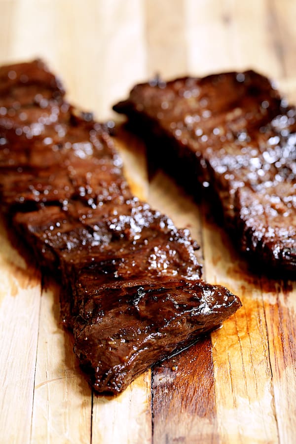 Photo of grilled skirt steak on wood cutting board.