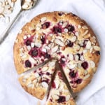 Raspberry Ricotta Cake with Almonds with two wedges cut from the whole cake.
