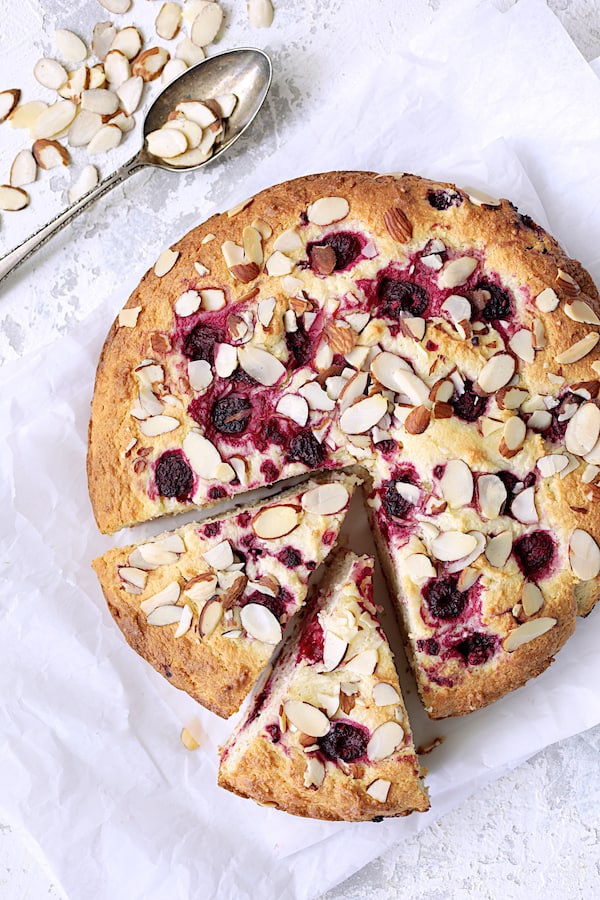 Photo of Raspberry Ricotta Cake with Almonds with two wedges cut from cake.