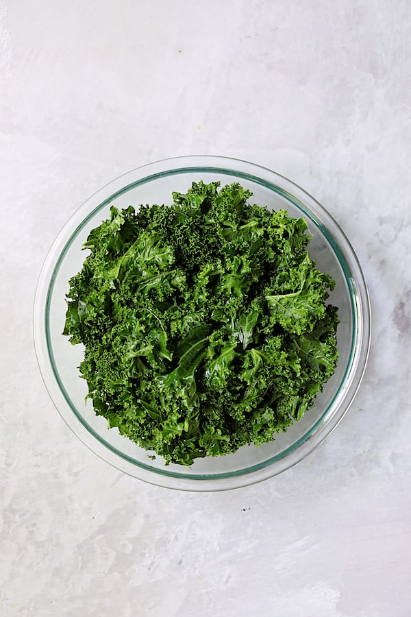 Photo of massaged kale in glass bowl.