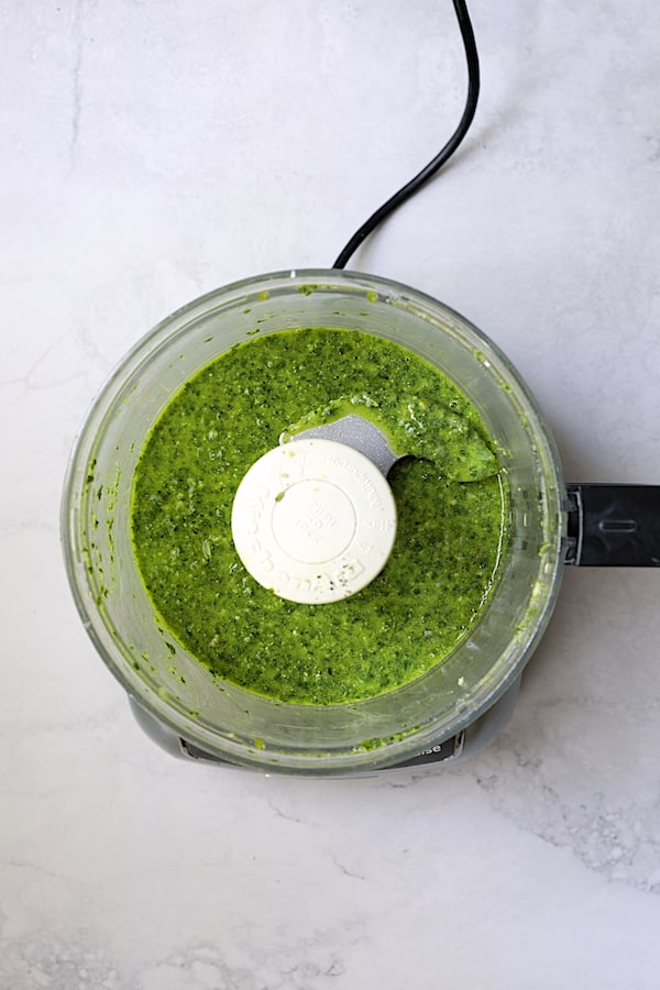 Photo of basil pesto dressing in food processor.