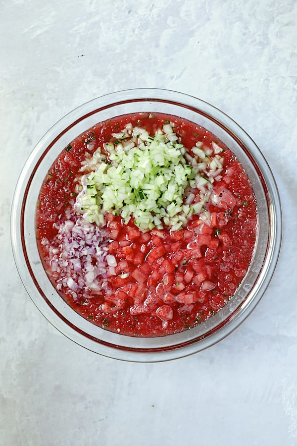 Photo of remaining ingredients for gazpacho being added to watermelon puree.