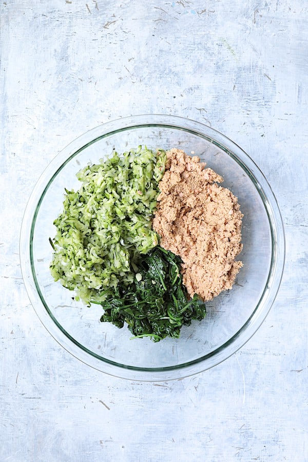 Photo of zucchini, red lentils and spinach in glass bowl.