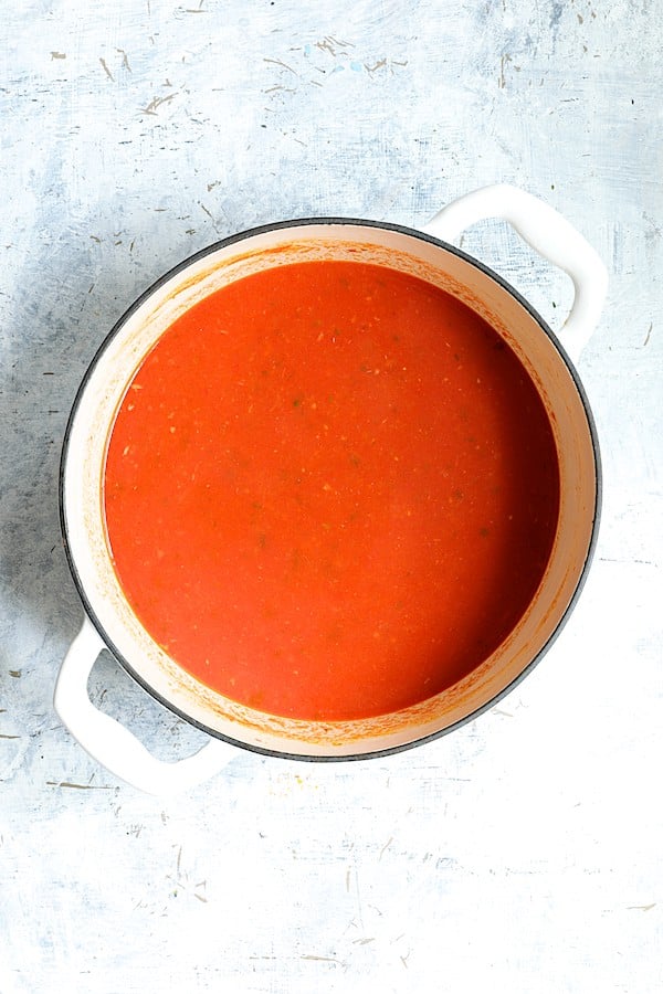 Photo of smooth sauce in white Dutch oven after being processed in a food mill.