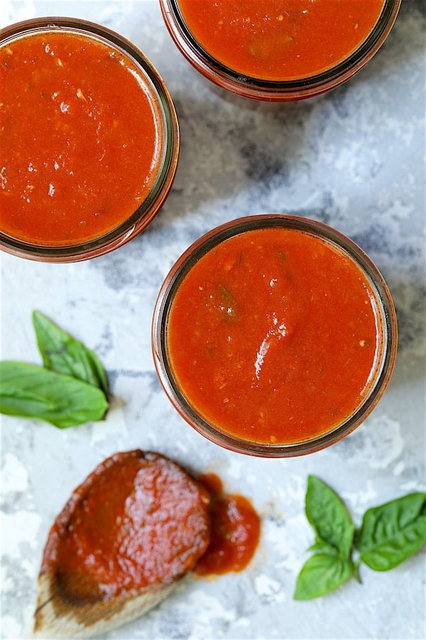 Close-up photo of Basic Fresh Tomato Sauce (Parma Style) in glass pint jars.