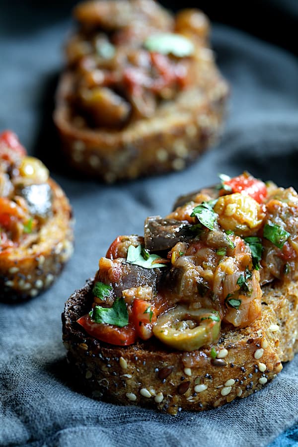 Close-up photo of Moroccan-Spiced Caponata on crusty bread.