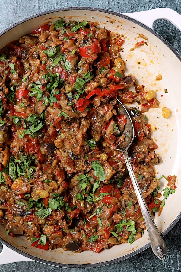 Close-up photo of Moroccan-Spiced Caponata in white cast iron skillet.