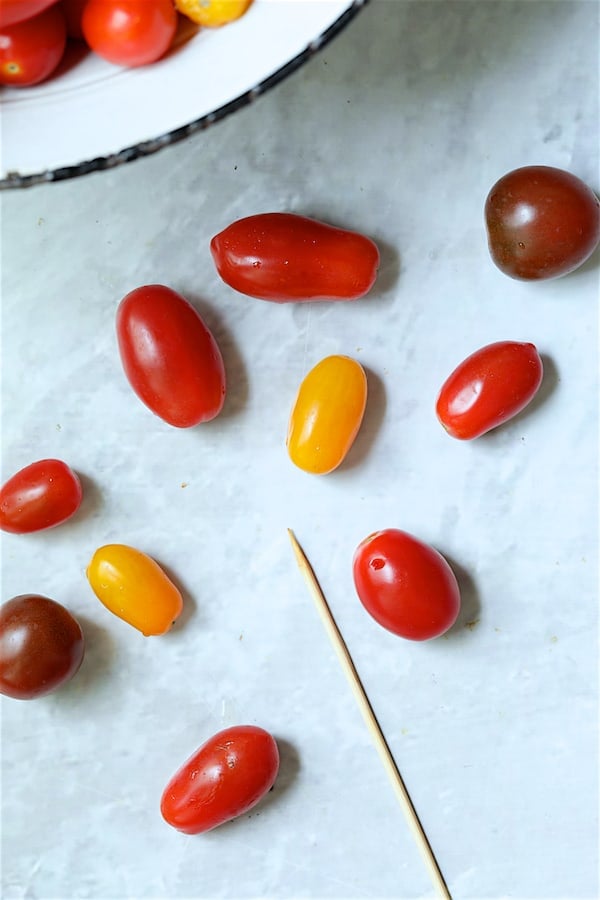 Photo showing how to prick the tomatoes with wooden skewer before canning.