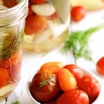 Pickled Grape Tomatoes - Close-up shot of pickled tomatoes in small white bowl garnished with dill