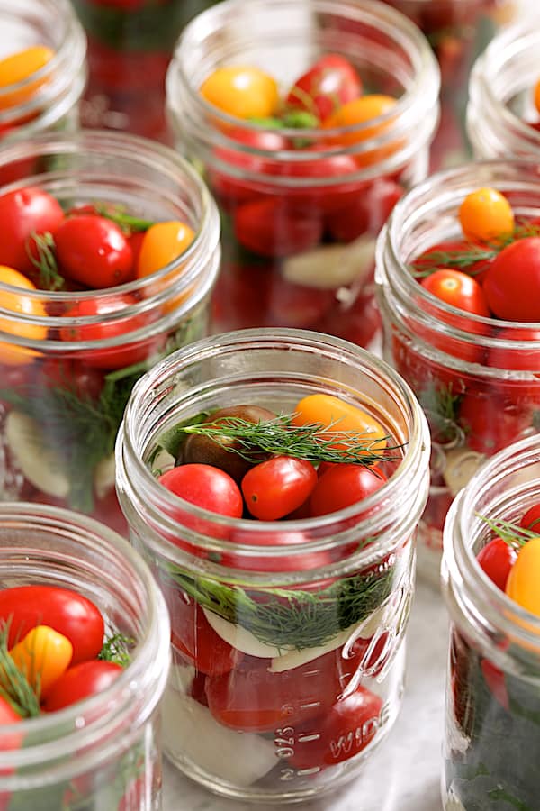 Photo of grape tomatoes in glass pint jar before brine is added.