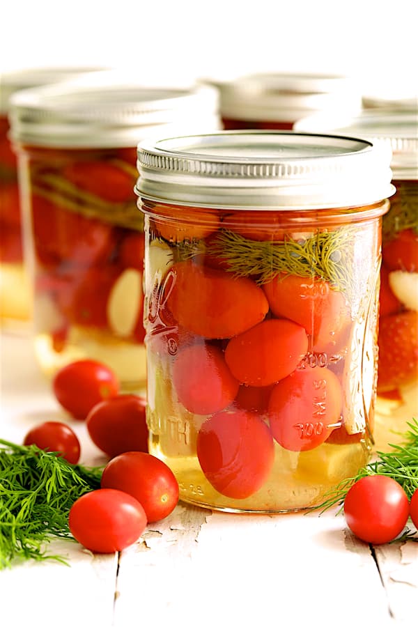 Photo of finished Pickled Grape Tomatoes in glass pint jars.
