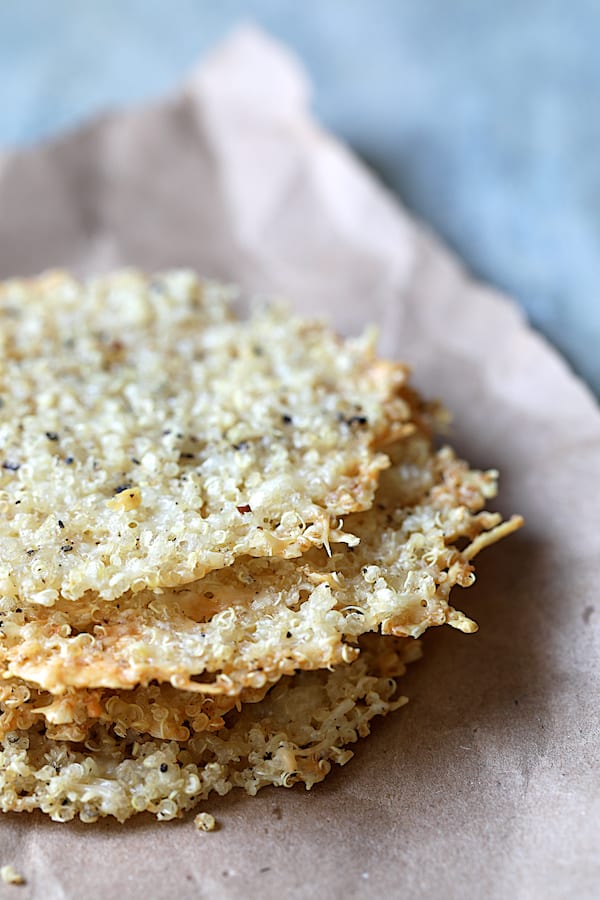 Photo of three Quinoa Parmesan Crisps on brown craft paper.