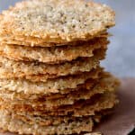 Quinoa Parmesan Crisps - Close up shot of a tall stack of the crisps on brown wrapping paper