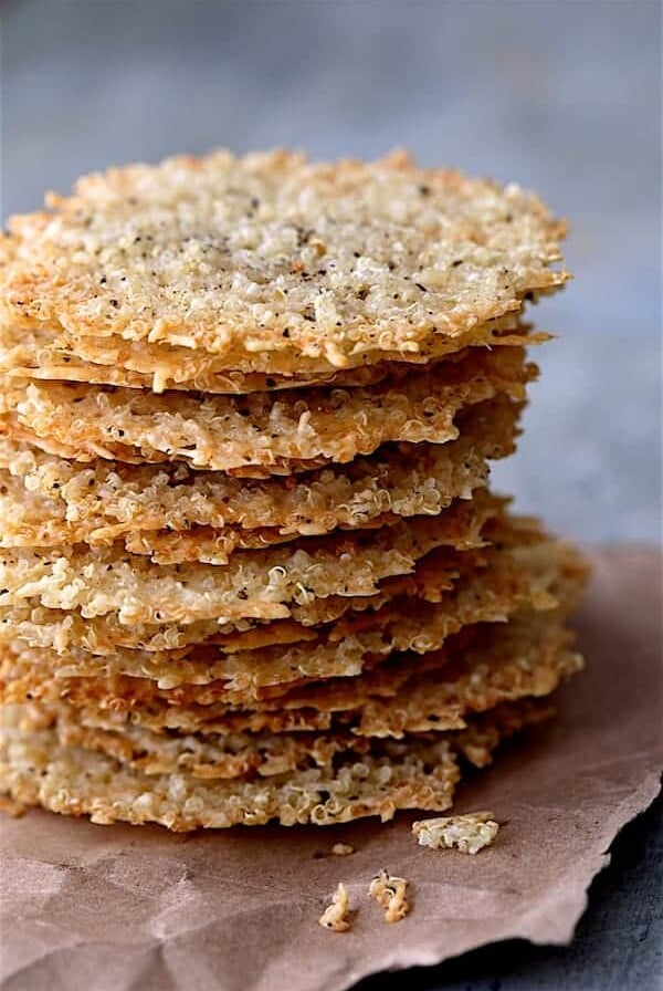 Quinoa Parmesan Crisps - Close up shot of a tall stack of the crisps on brown wrapping paper